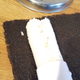 An imperfect, slightly fissured cylinder of rice extruding from the Sushi Bazooka onto some nori